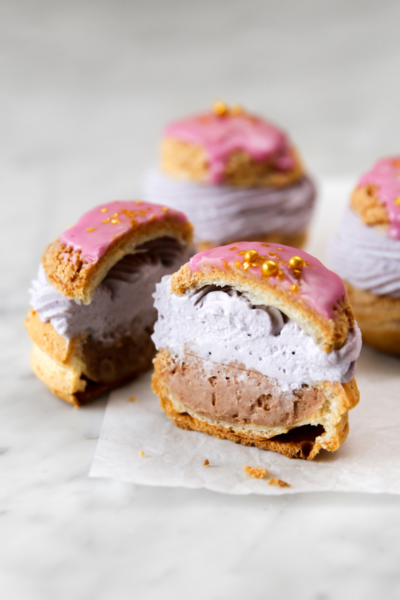 Cream puffed filled with chocolate ganache and purple cream and topped with pink glaze.