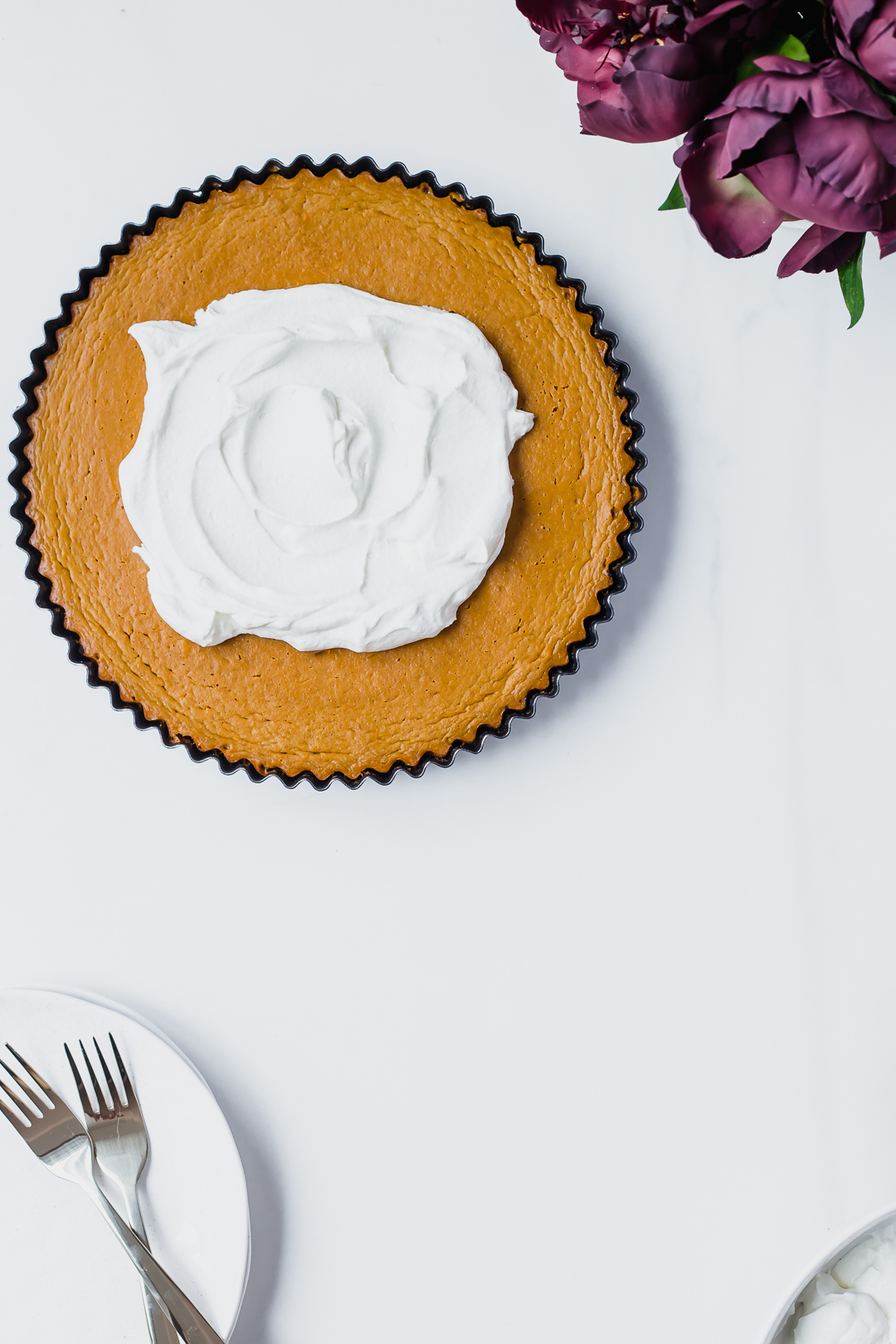 Overhead shot of Pumpkin Pie with chocolate cookie crust topped with whipped cream