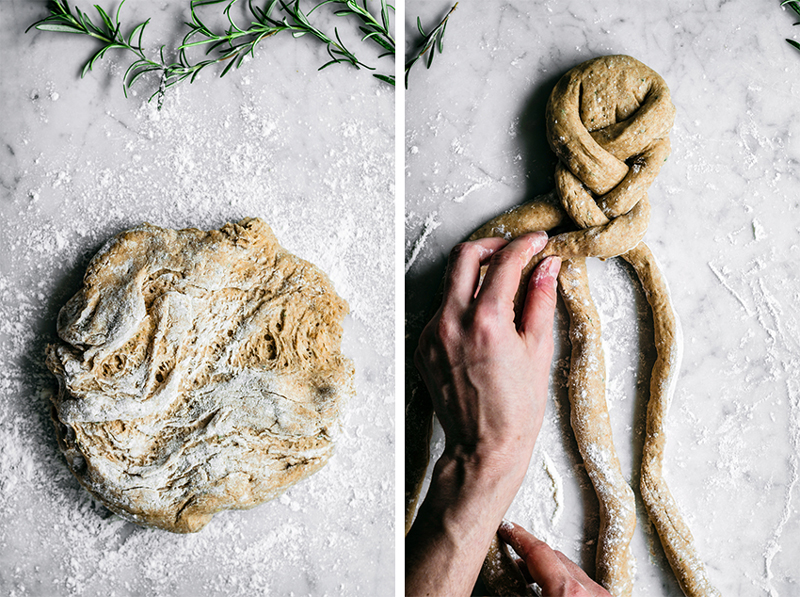 Braided rosemary rye bread on marble background with rosemary in upper corners