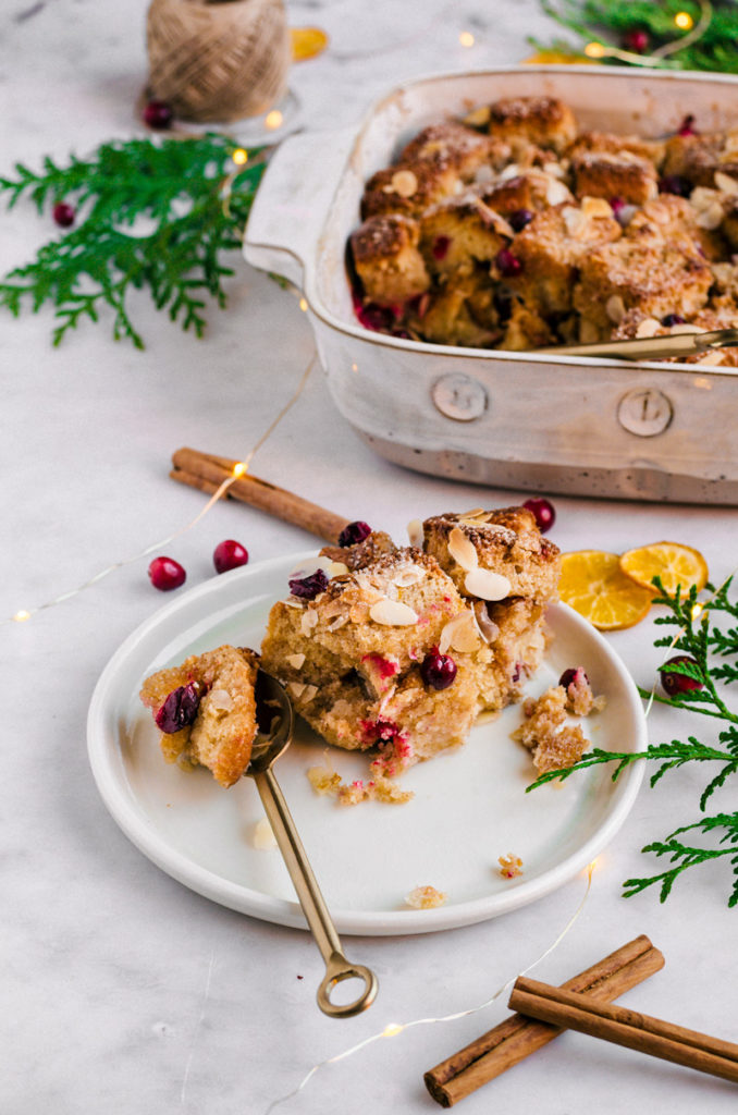 A serving of cranberry almond brioche bread pudding on a plate.