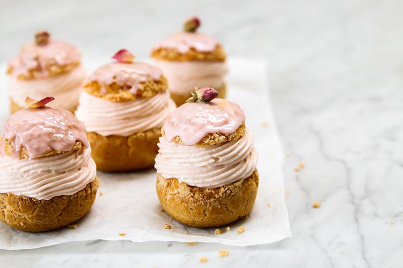 Choux buns with pink filling and icing.