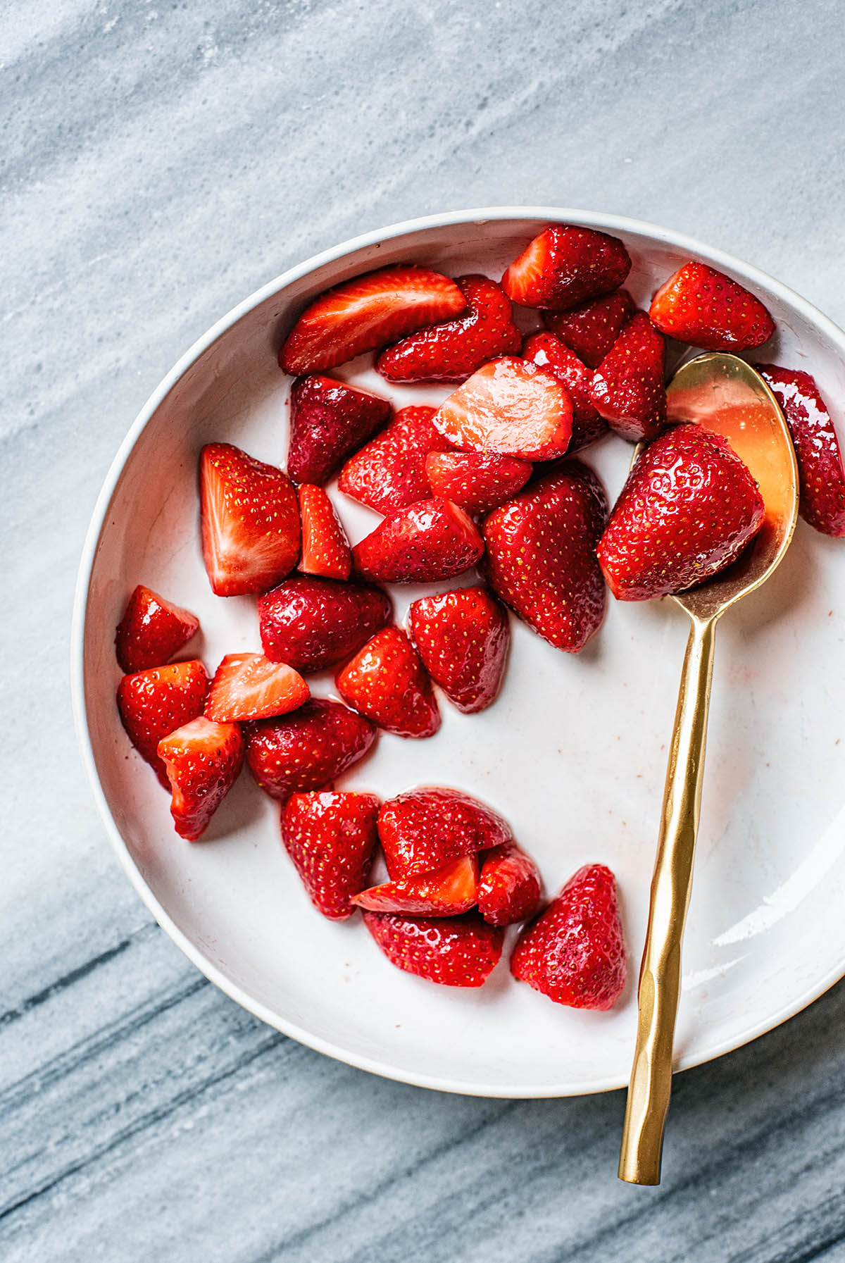 Shallow bowl with strawberries and honey.