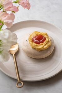 A meringue nest filled with lemon curd and topped with jam.