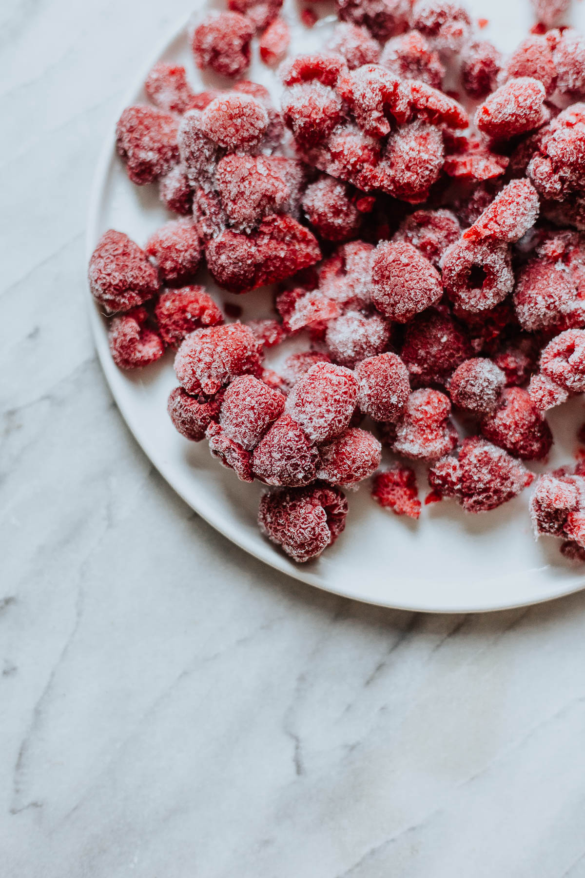 A plate of frozen raspberries.