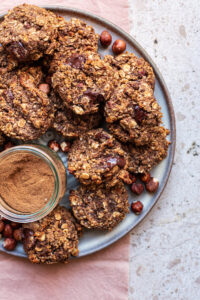 A plate full of cookies with spices in a jar.