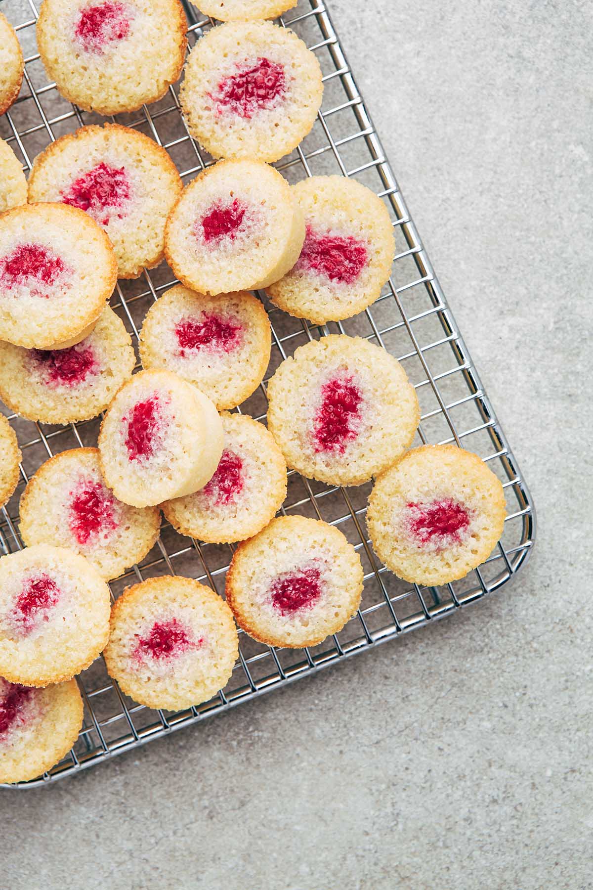 Raspberry financiers on a square cooling rack.
