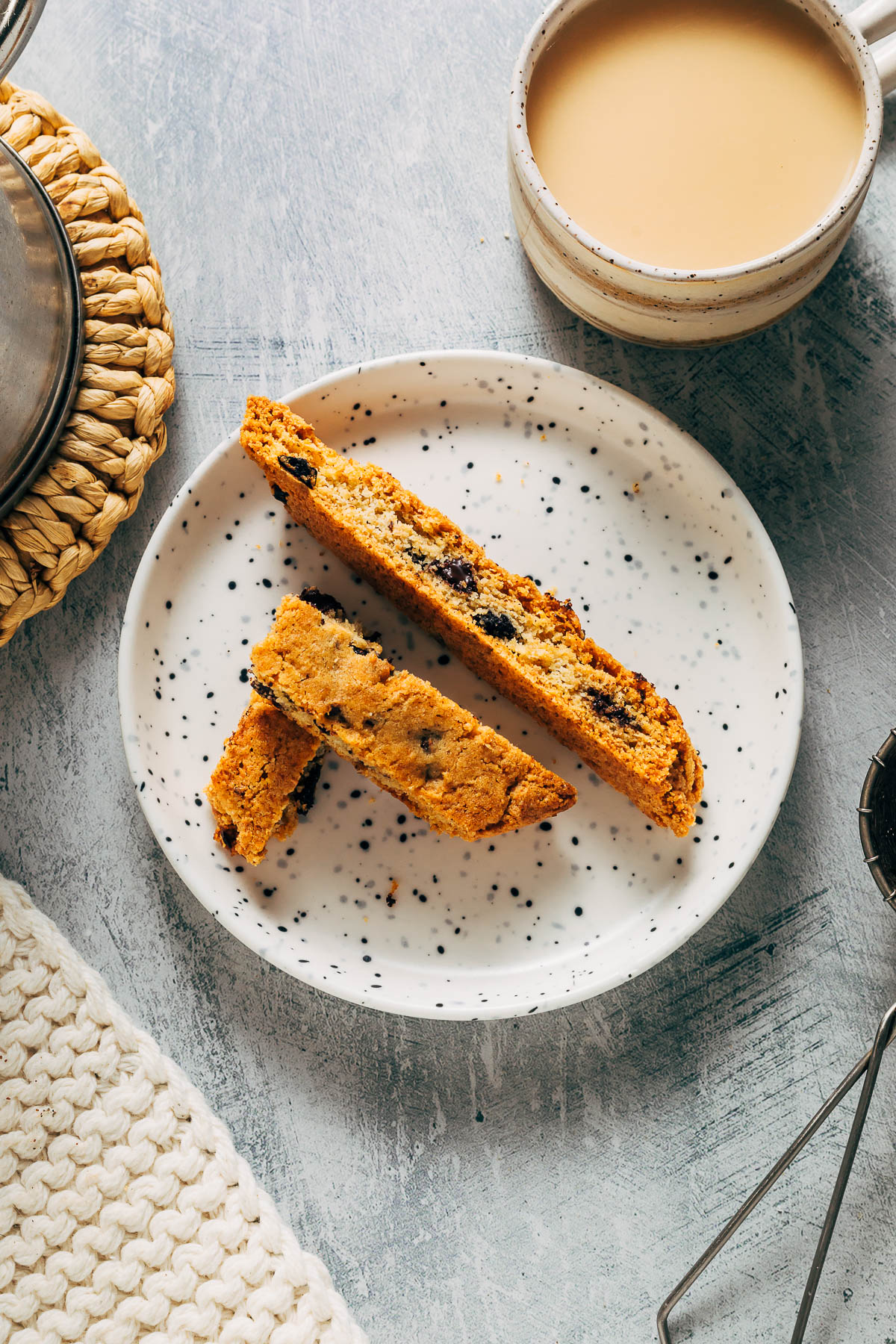 Biscotti on a small plate with milky coffee.