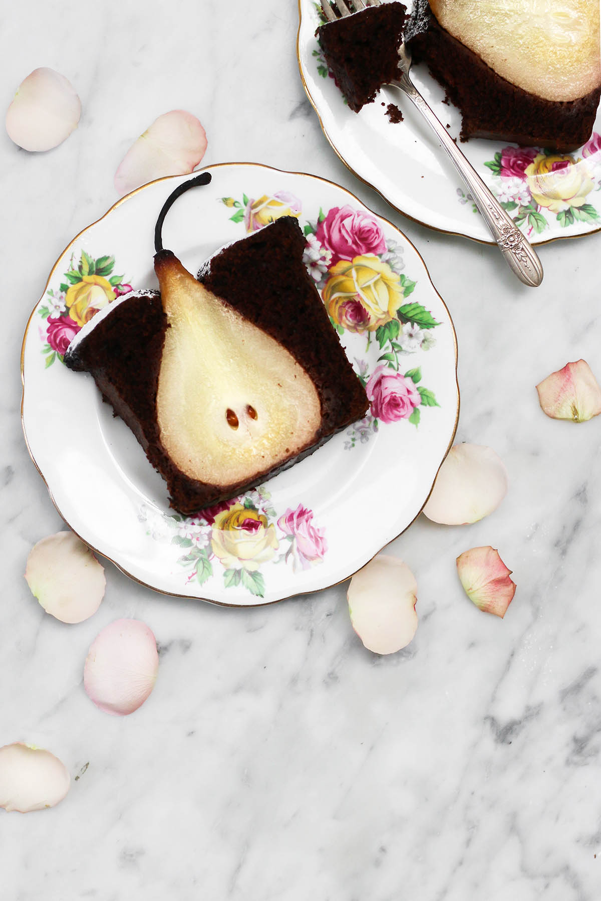 A slice of chocolate cake with a cross section of a poached pear inside the slice.