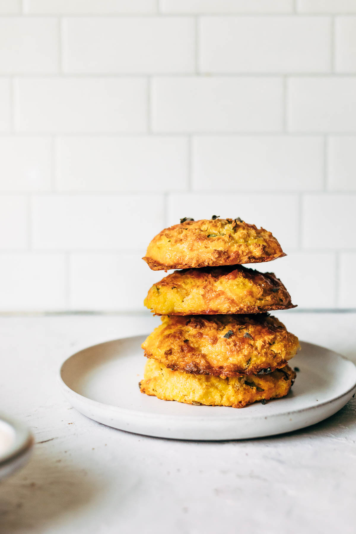 A stack of four gluten-free pumpkin scones on a white plate.