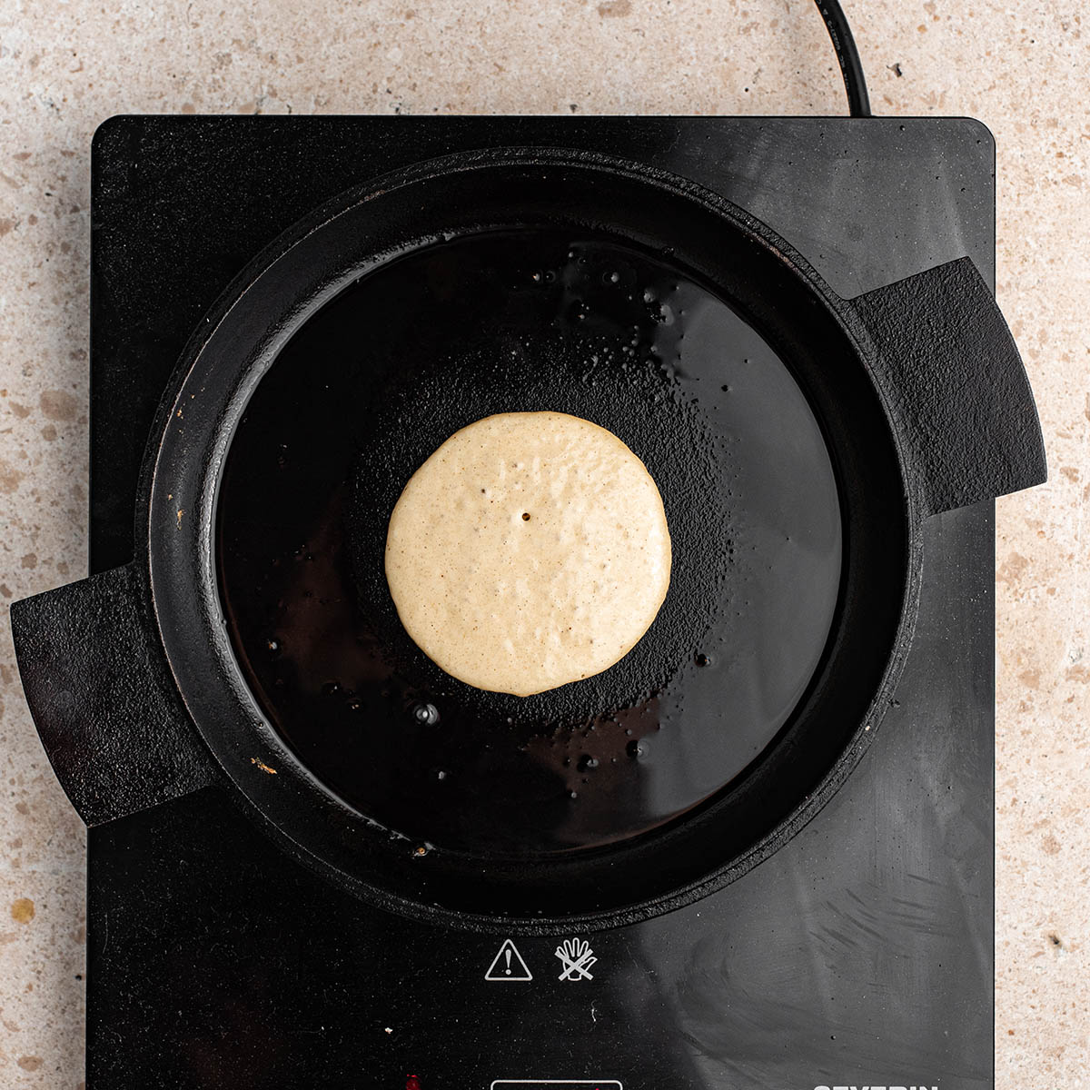 A pancake on a griddle.