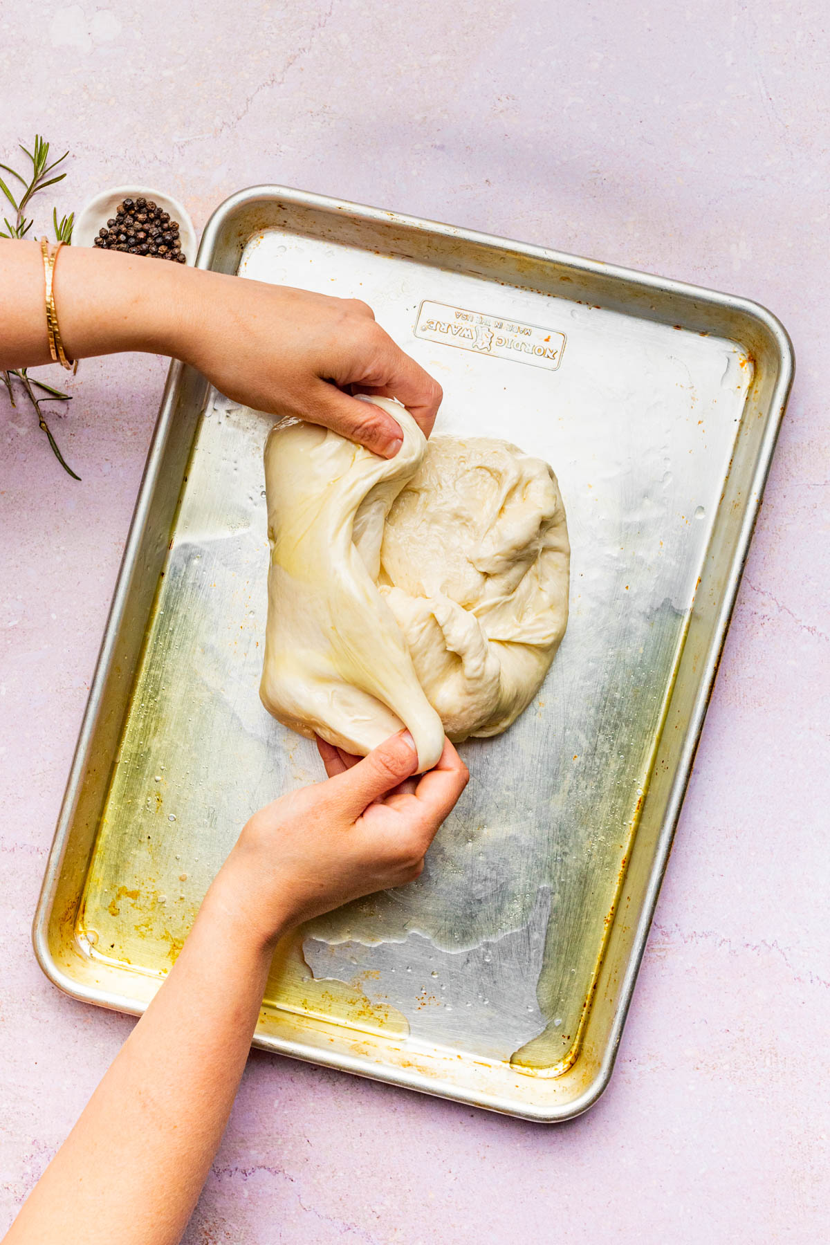 Stretching the dough on the baking sheet.
