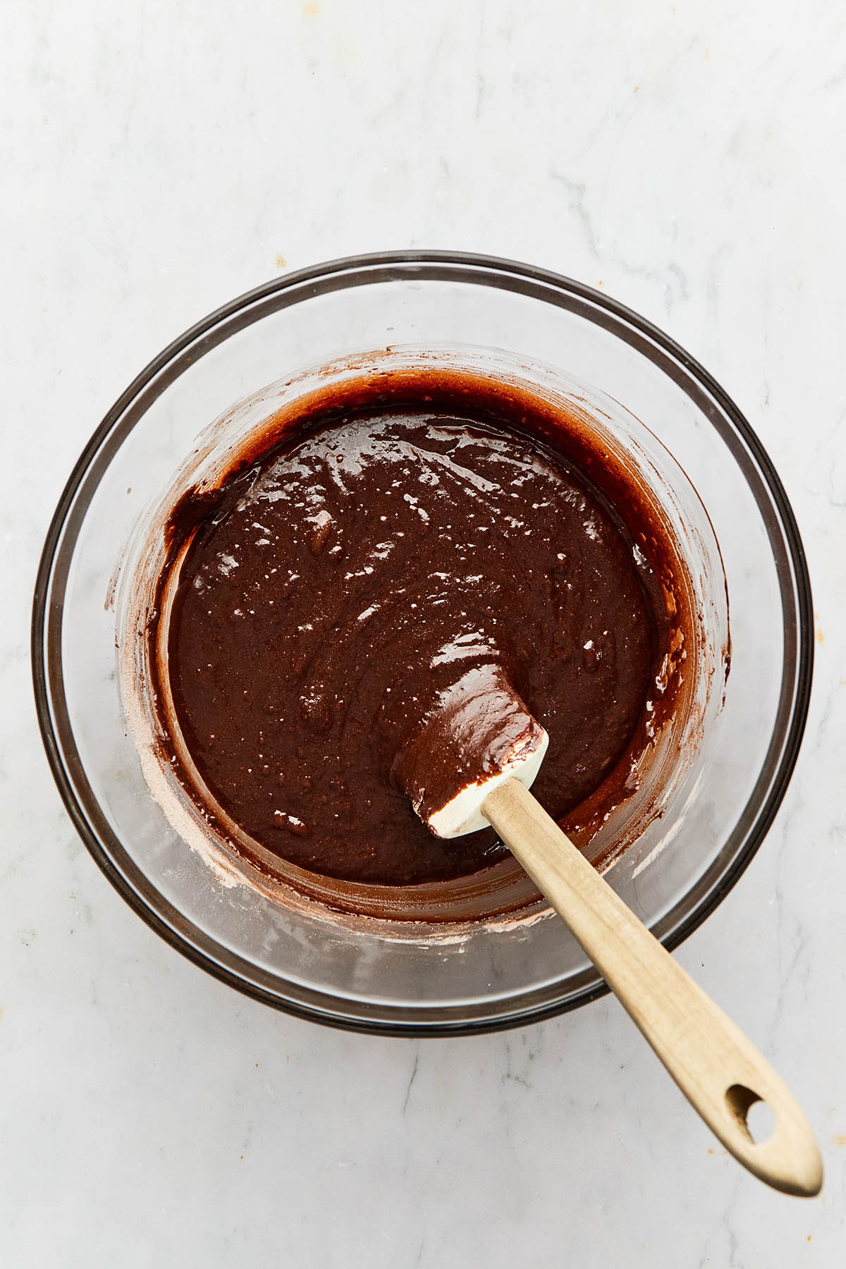 A large glass bowl of chocolate batter.