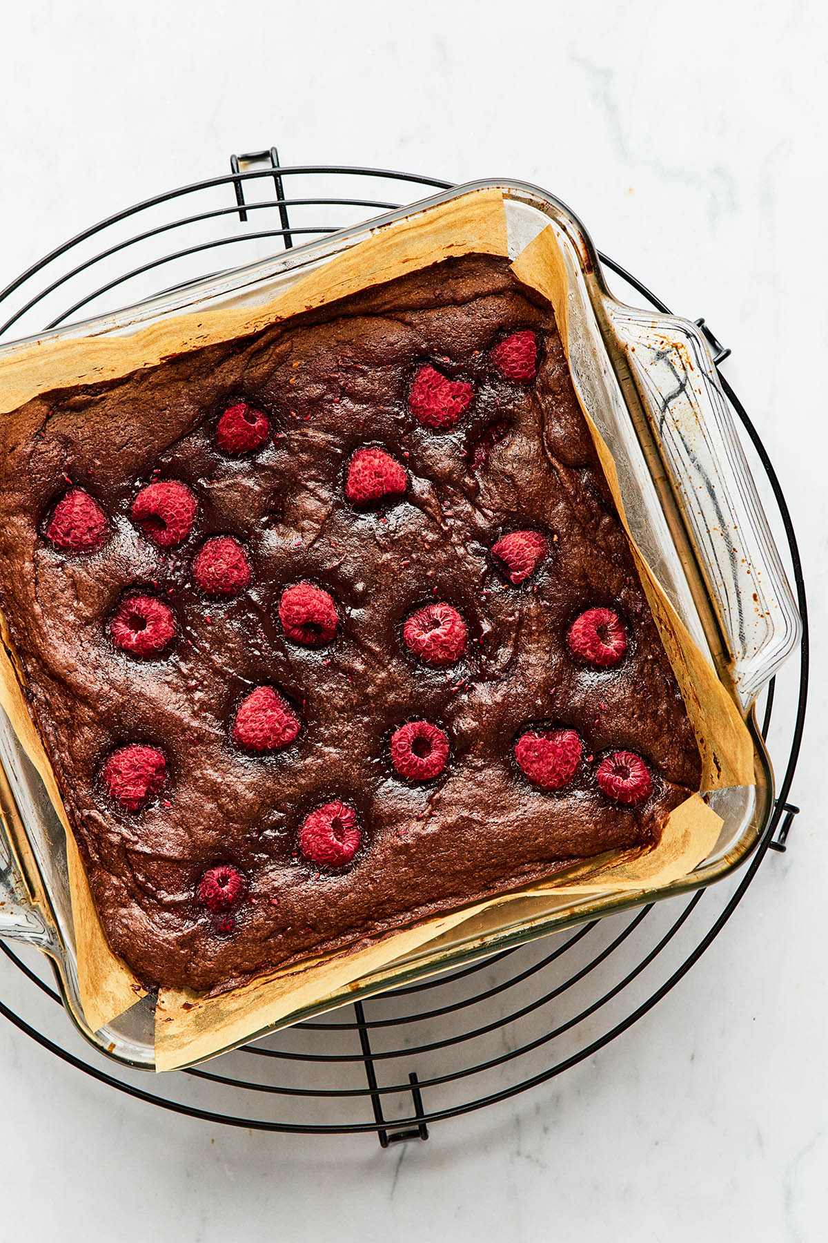 A pan of raspberry brownies on a cooling rack.