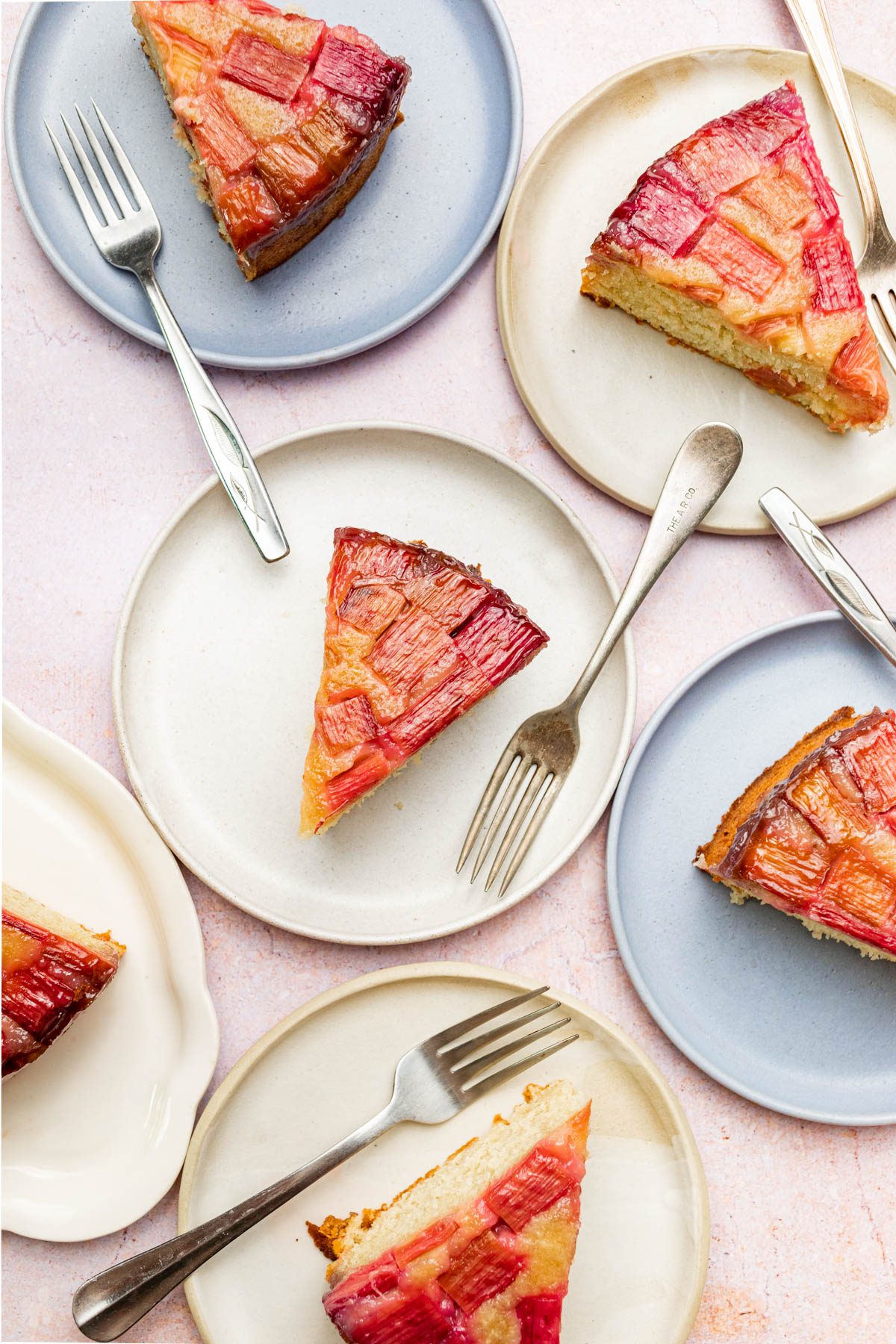 Several slices of rhubarb cake on plates.