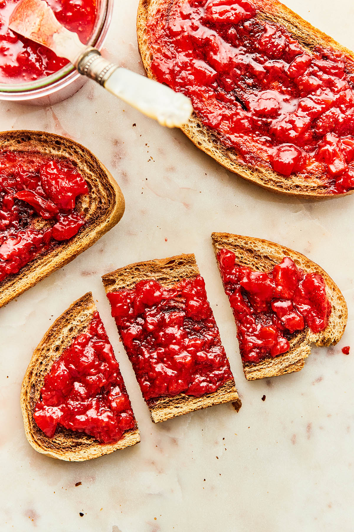 Toast with small-batch strawberry jam on a marble board.