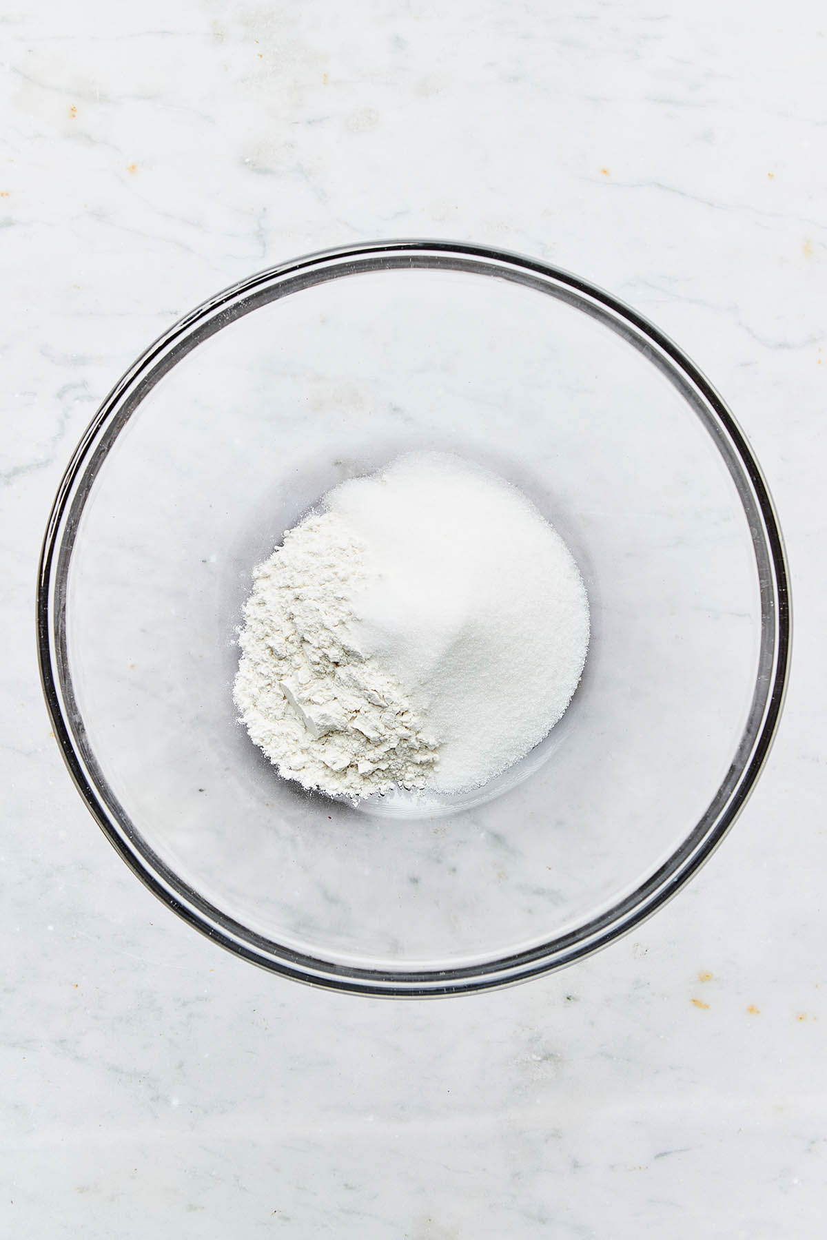 Flour, sugar, and salt unmixed in a bowl.