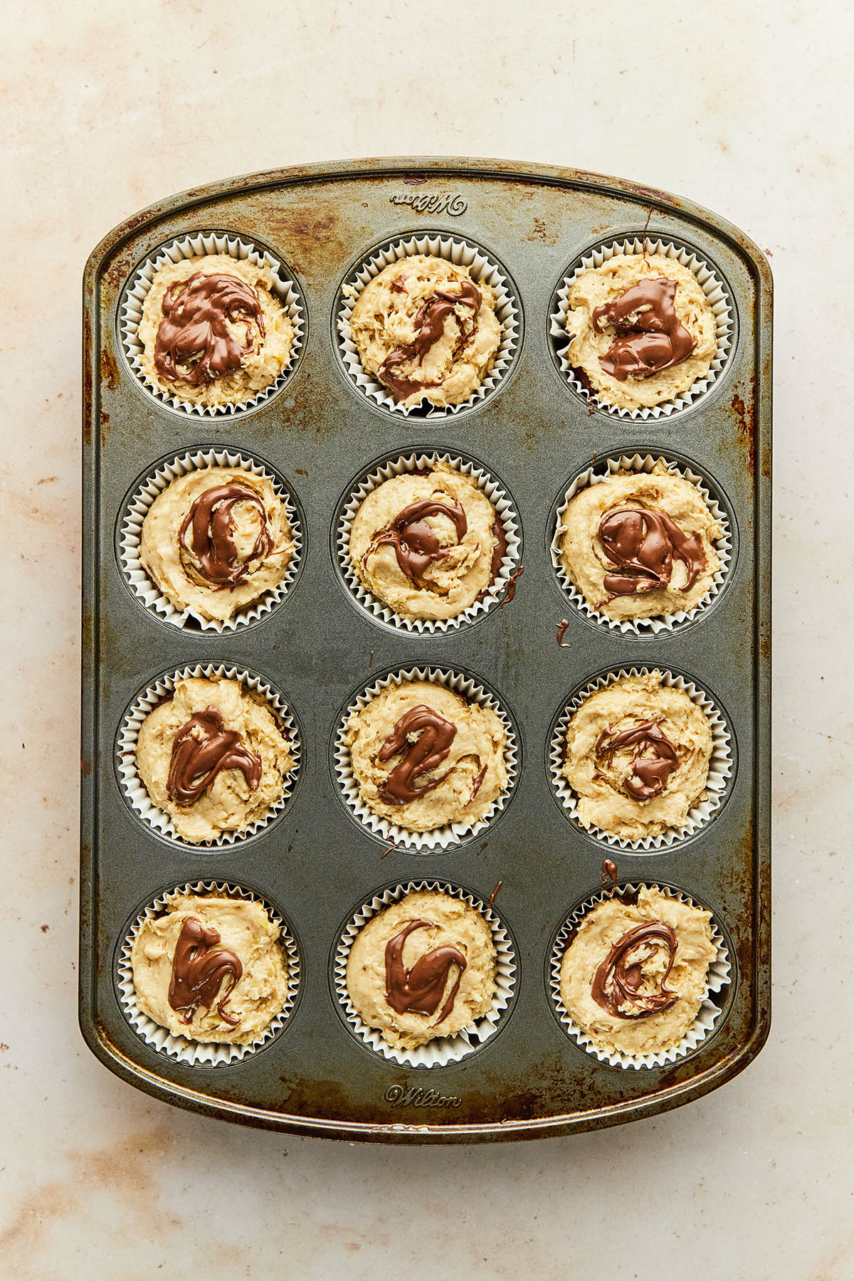 A pan of unbaked banana Nutella muffins.