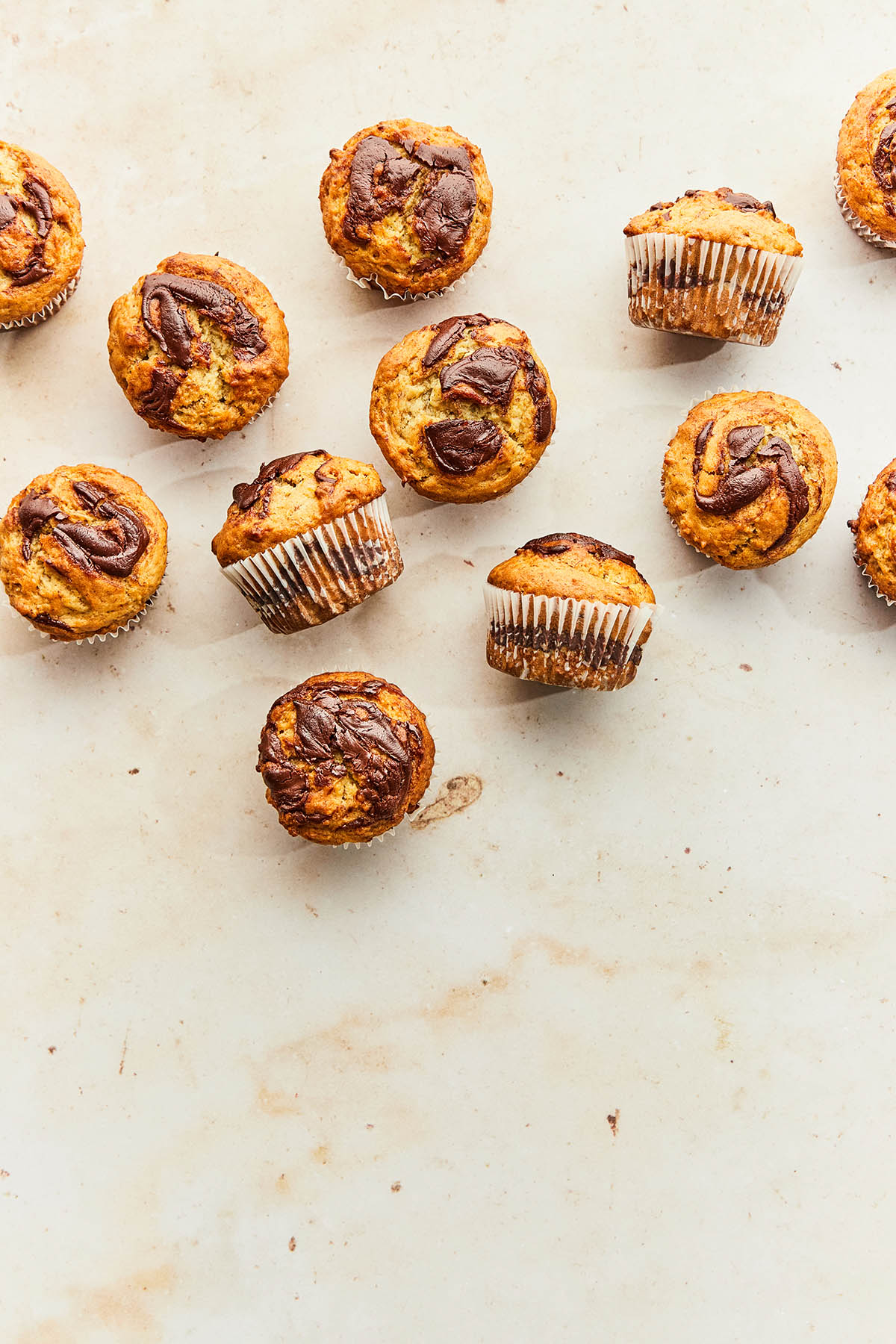 Banana Nutella muffins scattered on a marble surface.