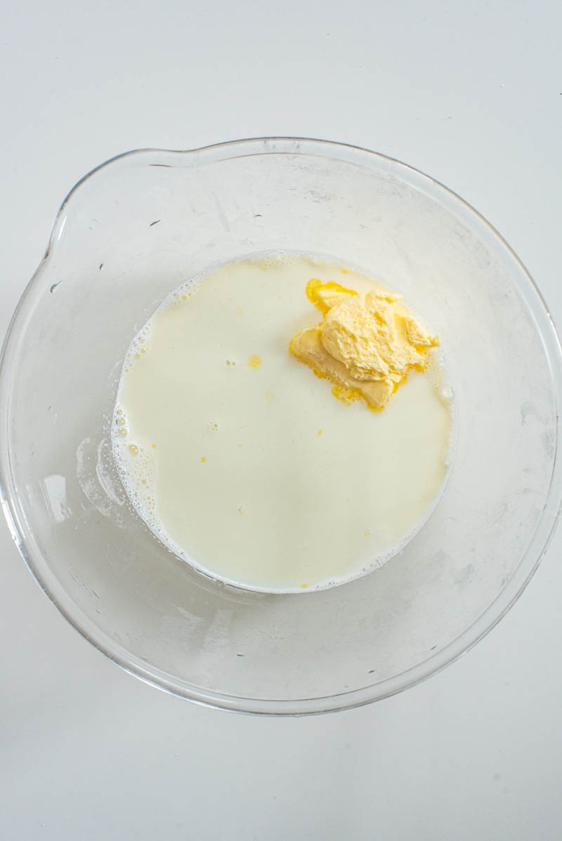 Sugar and butter added to the hot milk in a mixing bowl.