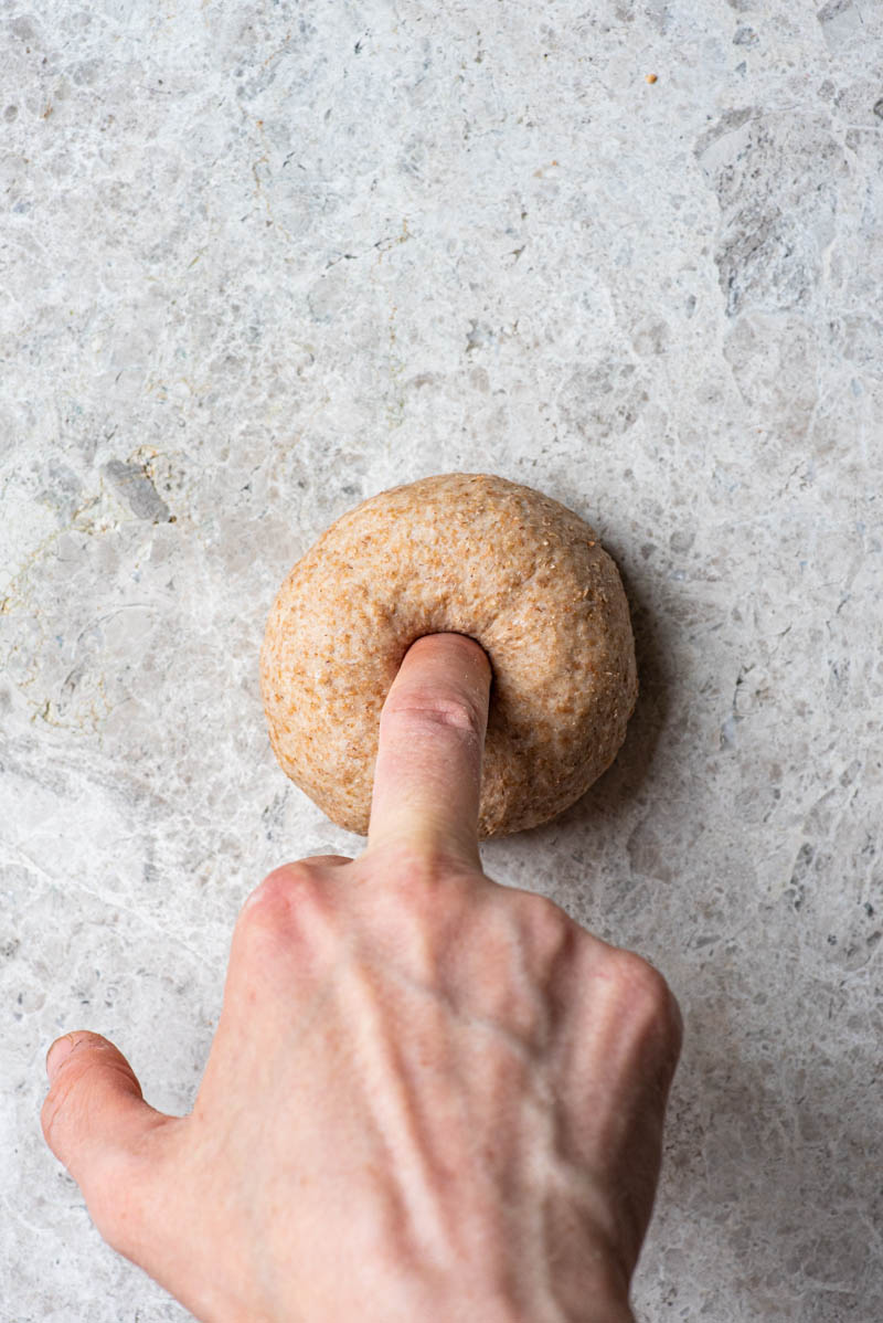 Pressing the centre hole into a bagel with one finger.