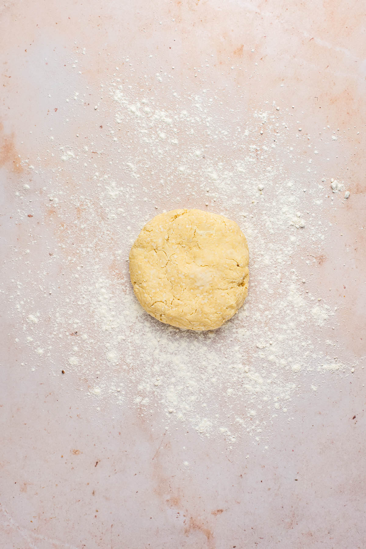 Pastry in a disc on a floured surface before rolling.