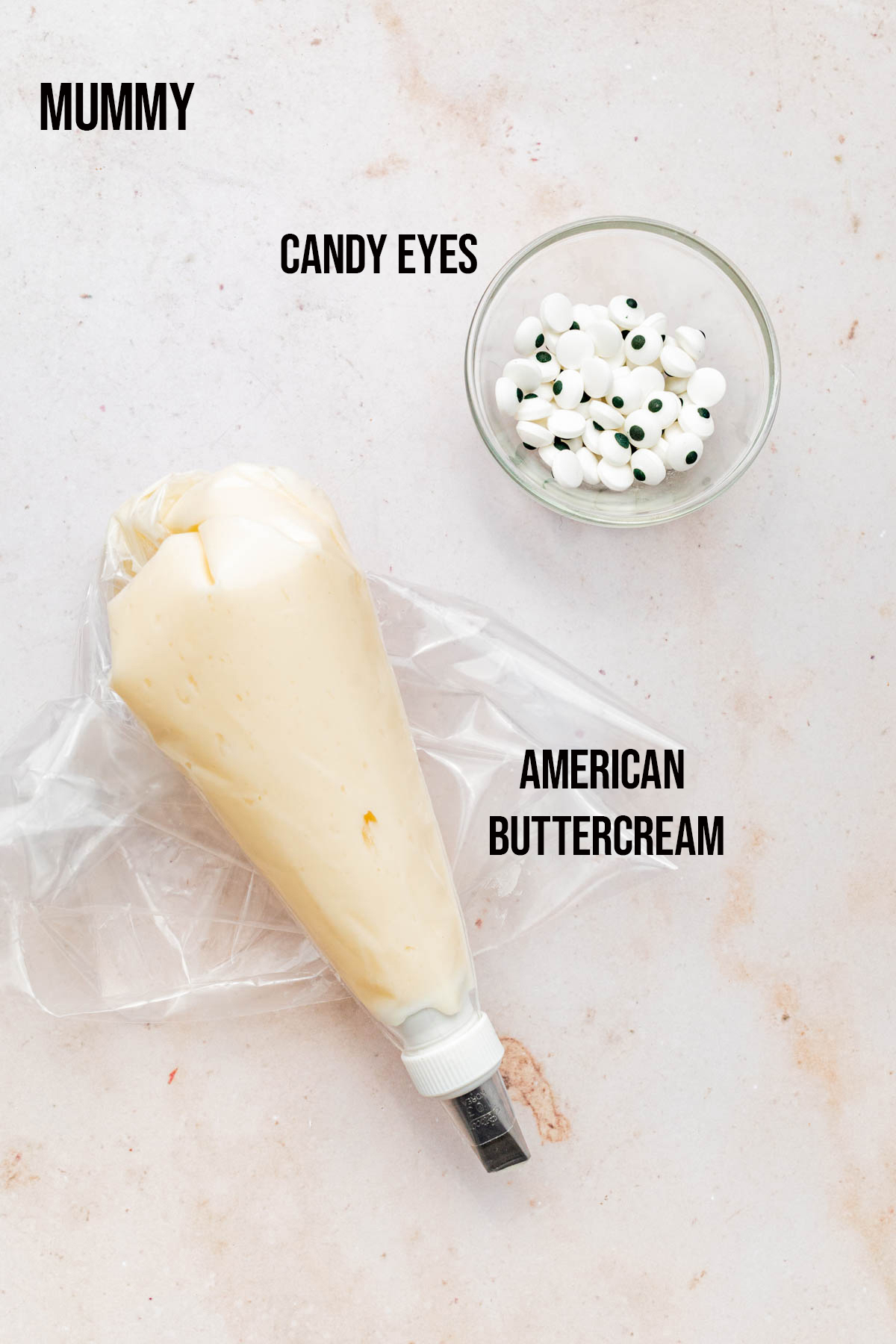 Candy eyes and piping bag of white frosting.