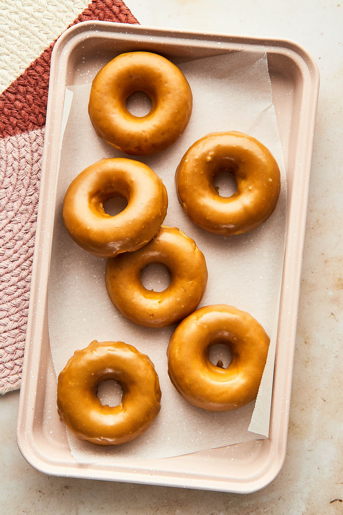 Overhead image of a batch of six oven-baked maple glazed donuts.