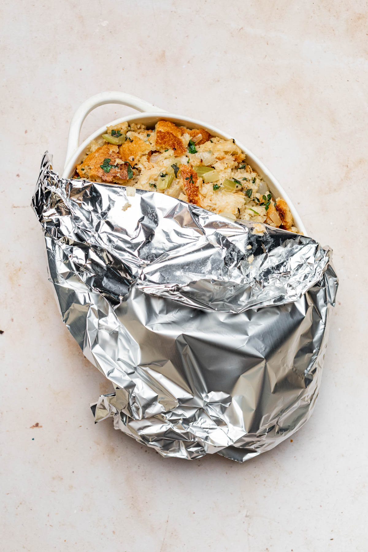 Tin foil being removed from baked stuffing.