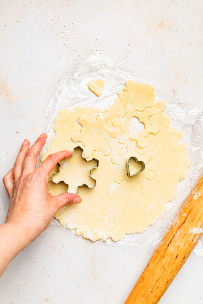 Cutting shapes out of rolled out dough.