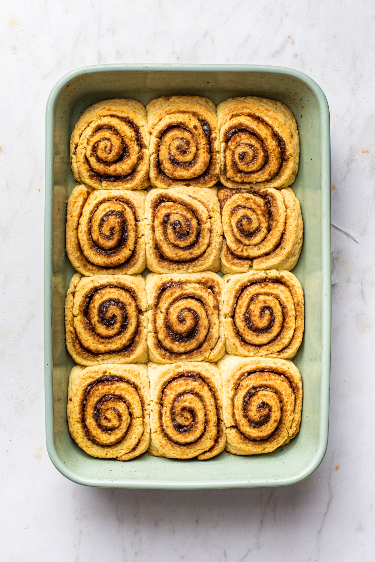 Baked rolls, now touching each other in the dish.
