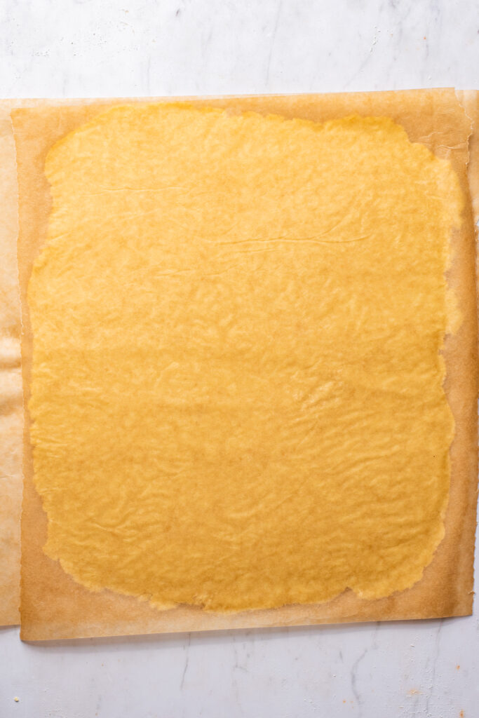 Dough rolled between two sheets of parchment paper.