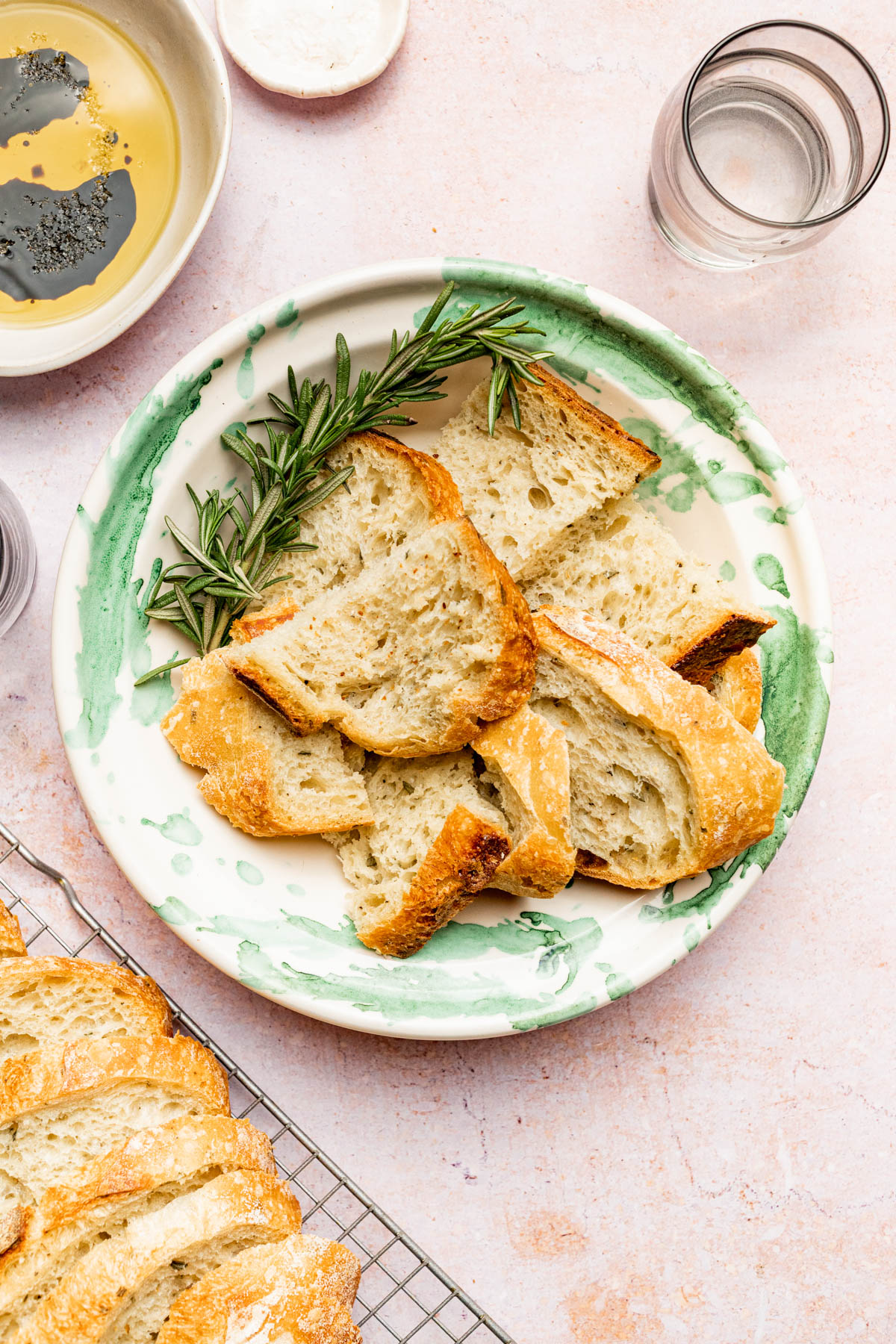 Halved slices of bread in a bowl with rosemary.