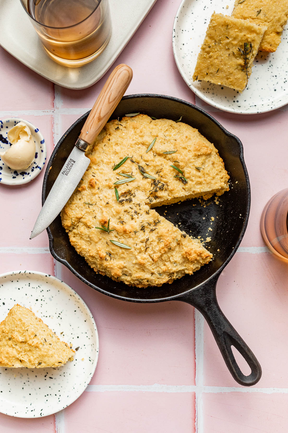Cornbread in a skillet with a wedge cut out.