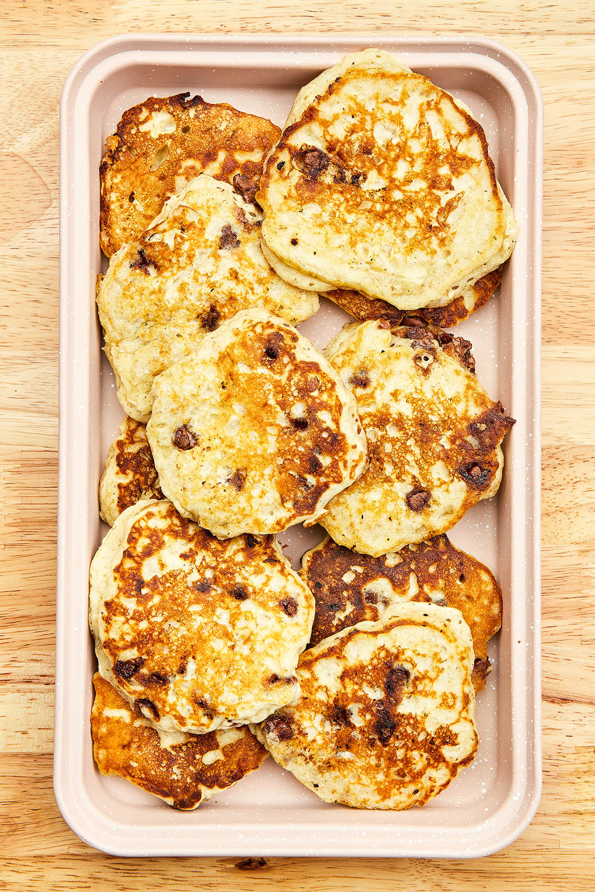 Overhead image of a baking tray filled with banana chocolate chip pancakes.