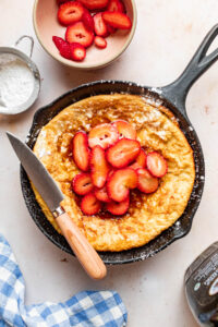 Overhead image of a baked gluten-free Dutch Baby in a cast iron skillet.