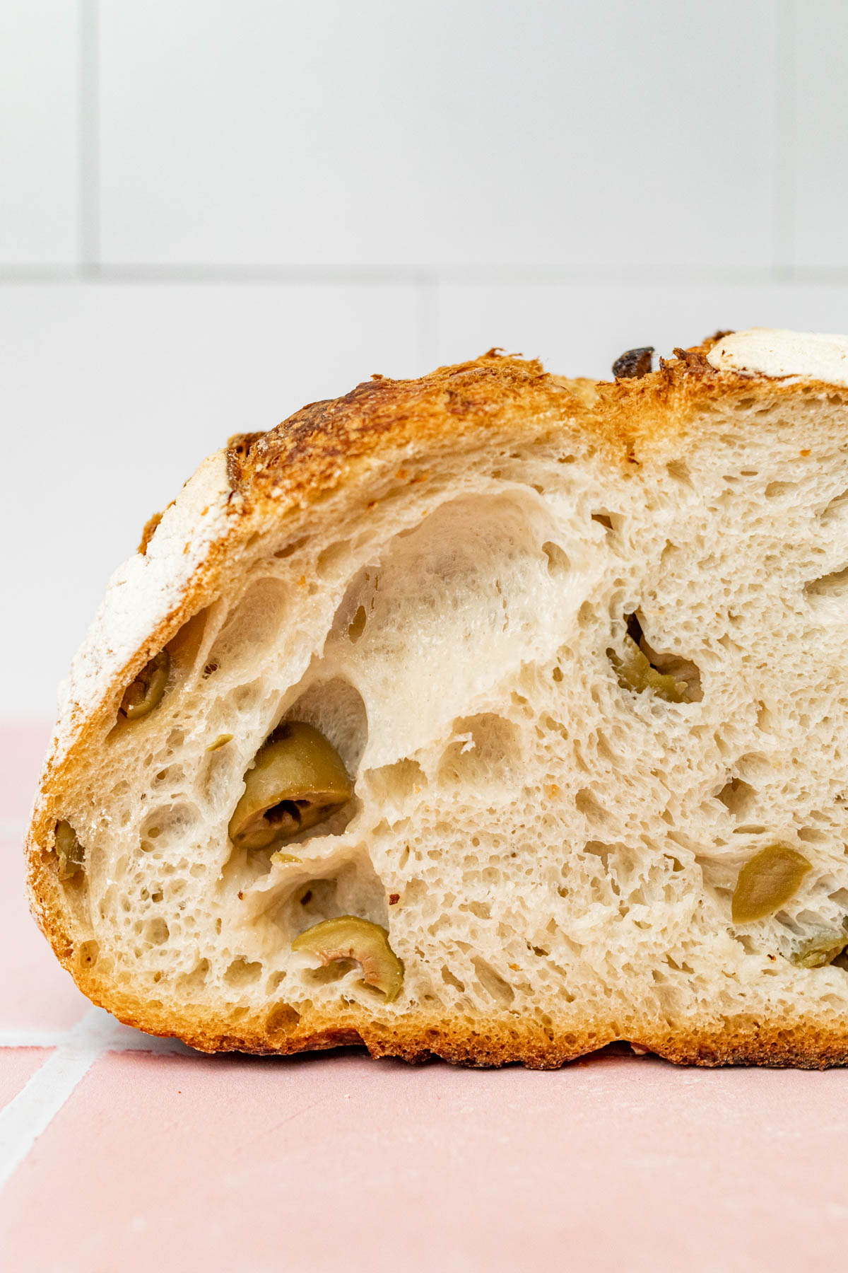 Cross section image of the inside of a loaf of sourdough olive bread.