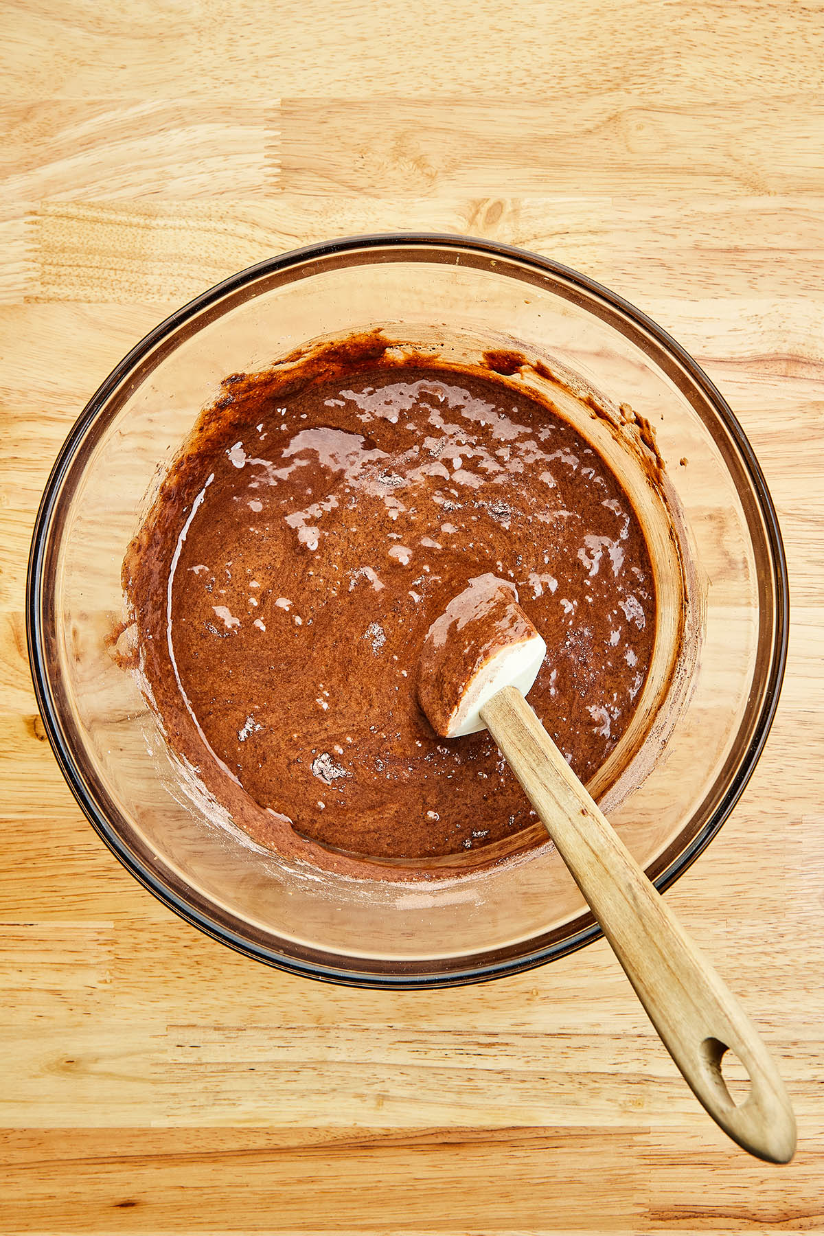 Mixed chocolate batter in a glass mixing bowl.