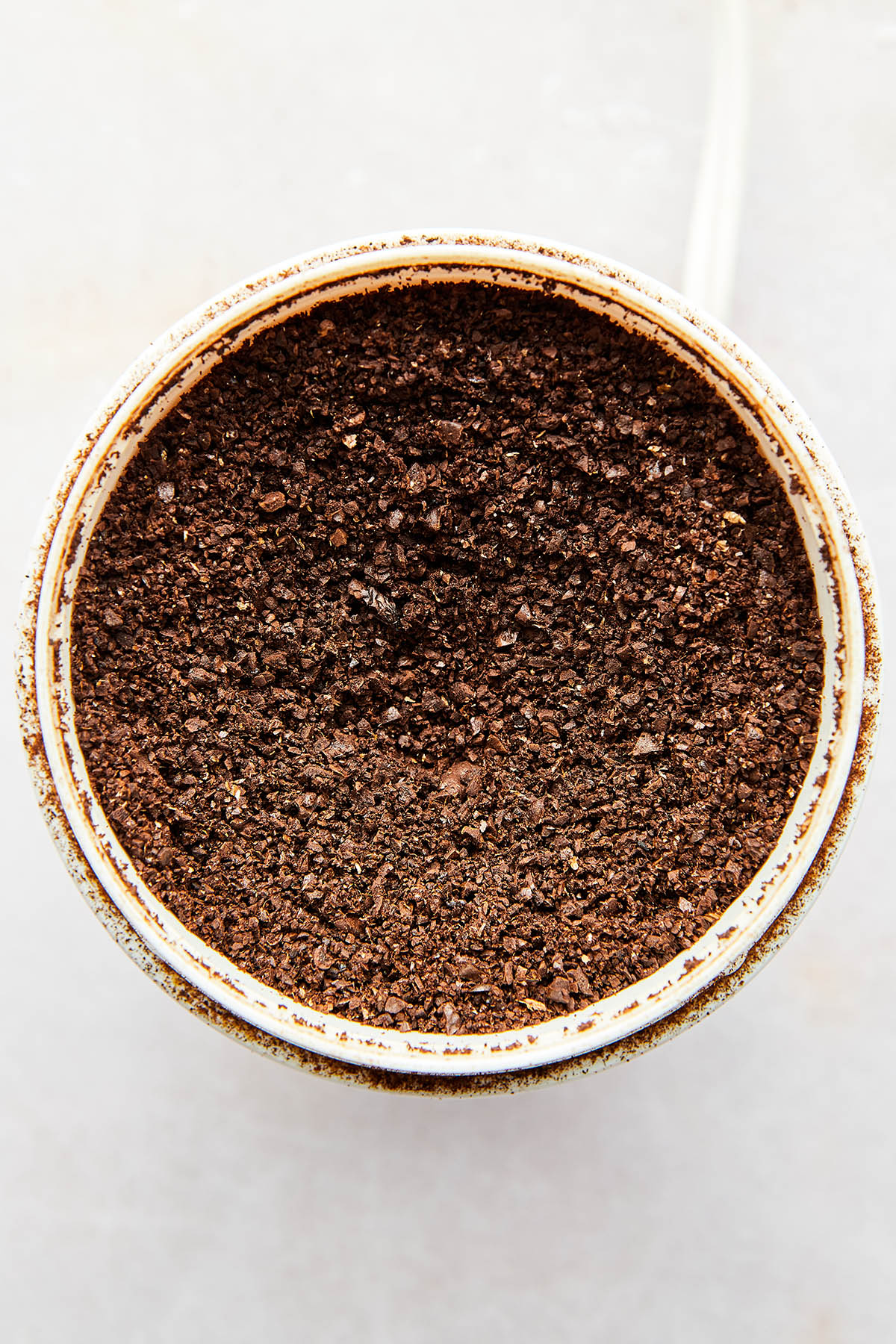 Coarse ground coffee inside a coffee grinder.