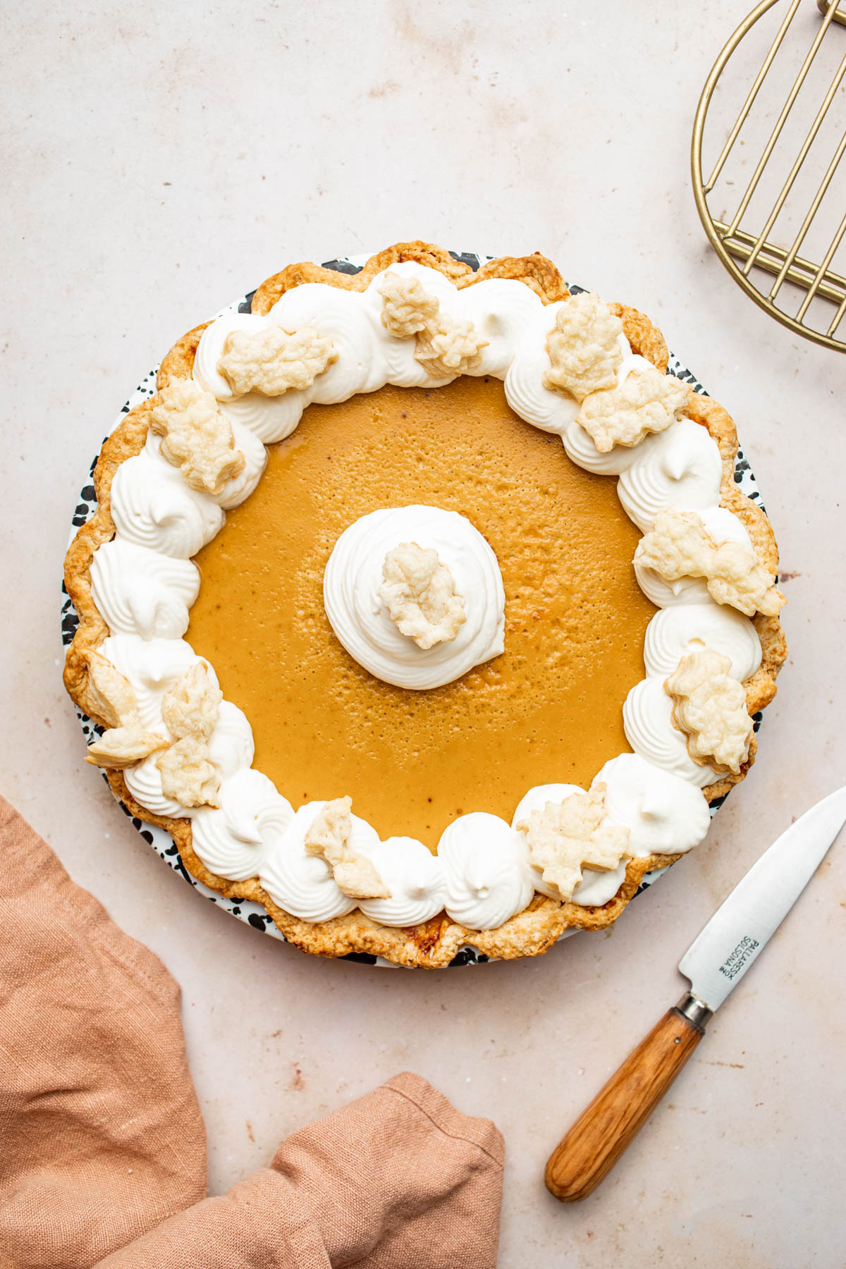 A pumpkin custard pie topped with whipped cream.